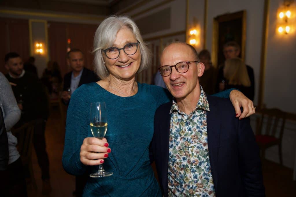 2 gæster ved fest holdende om hinanden