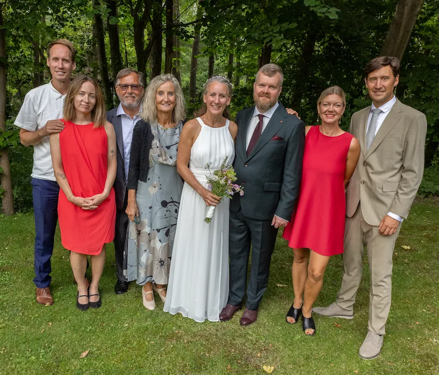Festfotograferne har her fotograferet brudeparret sammen med familie foran de grønne omgivelser.