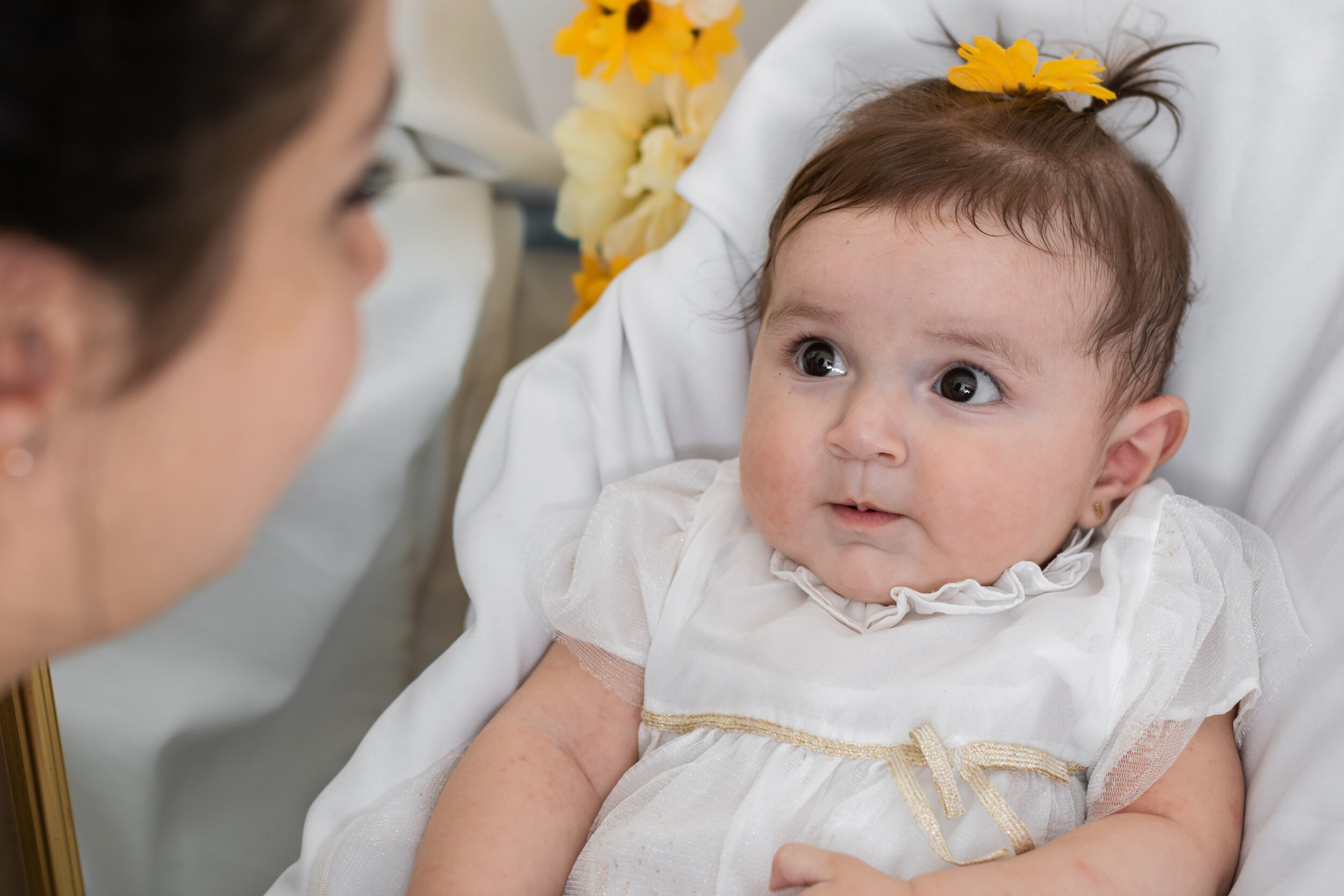 Dåbsbarn, der kigger afventede op på sin mor