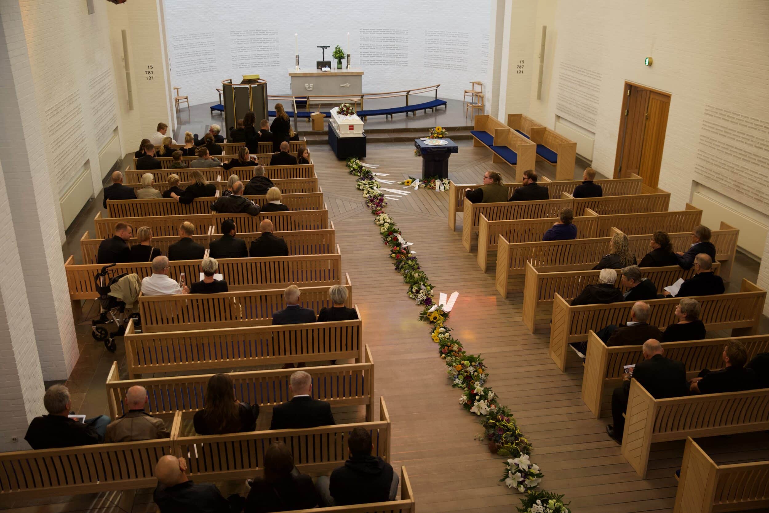 Billede af rækken af bådebuketter i kirke ved begravelse. Billedet er taget oppefra