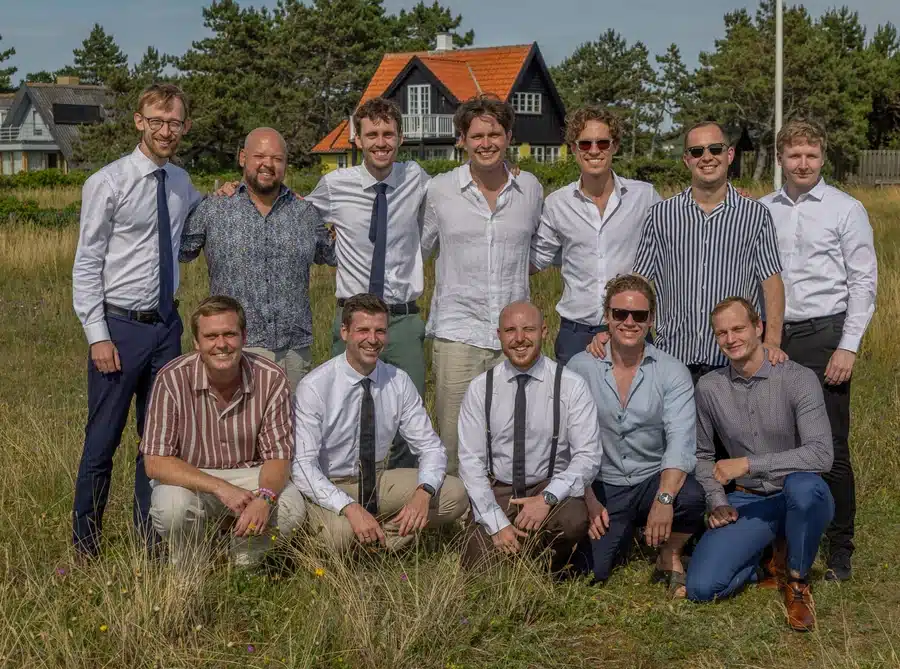 Bryllup 14 Festfotograferne har her fotograferet en gruppe mandlige bryllupsgæster, der poserer sammen udendørs på bryllupsdagen.