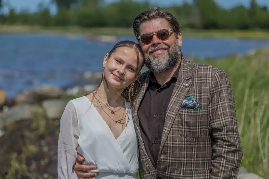 Festfotograferne har her fotograferet til en konfirmation. Efter kirken fik konfirmanden taget portrætfotos. På dette billede ses den kvindelige konfirmand med sin far. I baggrunden ses træer og vand